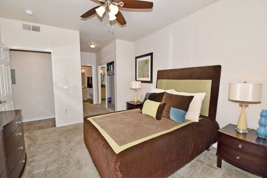 a bedroom with a large bed and a ceiling fan