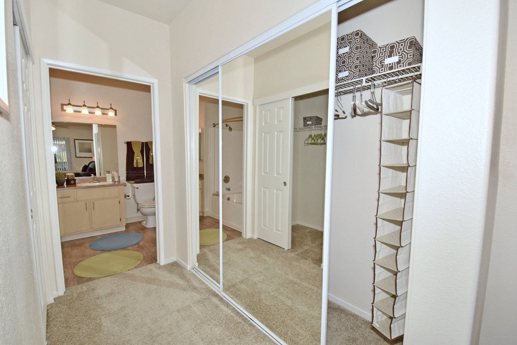 a reflection of a bathroom and a closet in a mirror