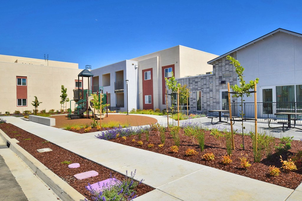 a courtyard in front of a building with benches and plants