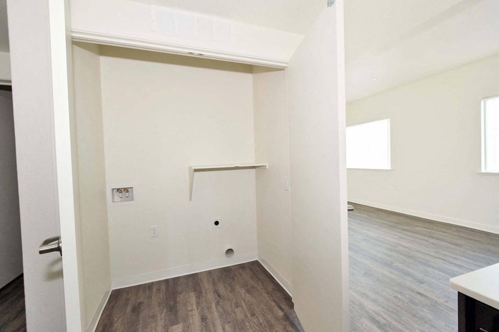 a bedroom with hardwood floors and white walls