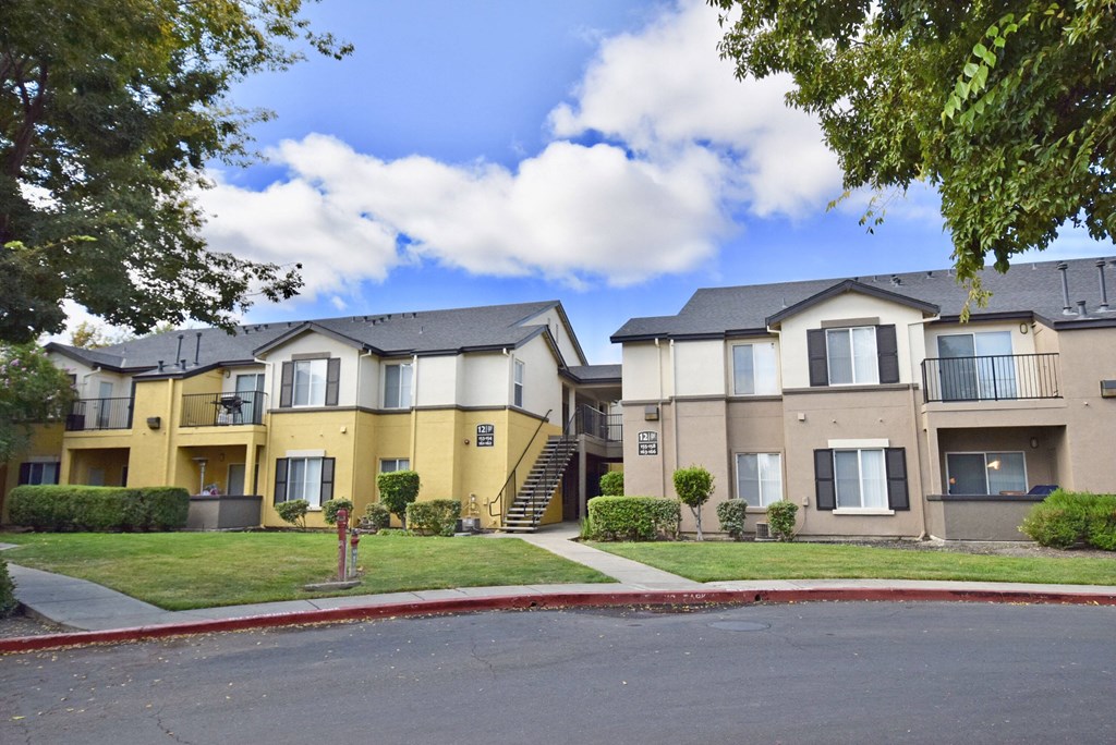 the view of two apartment buildings with a street in front of them