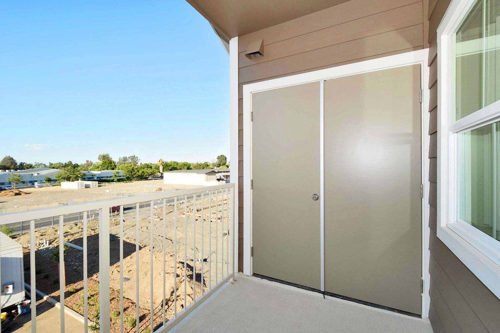 a glass door on a balcony with a view of a construction site