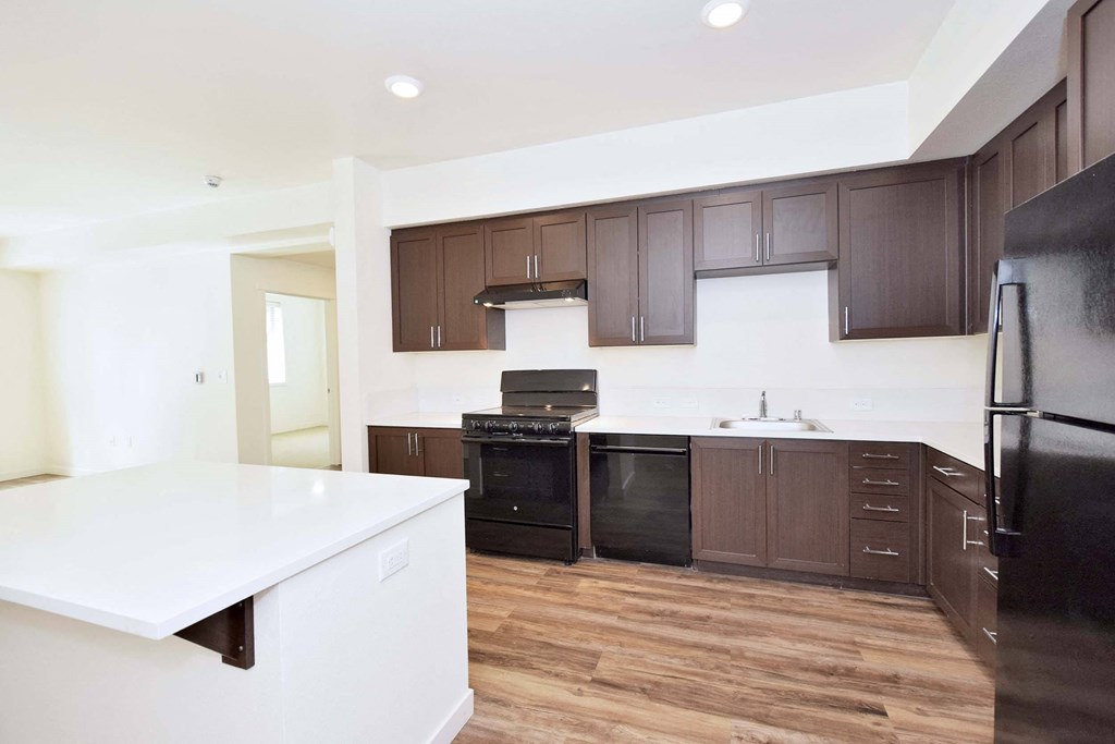 a large kitchen with dark wood cabinets and white counter tops