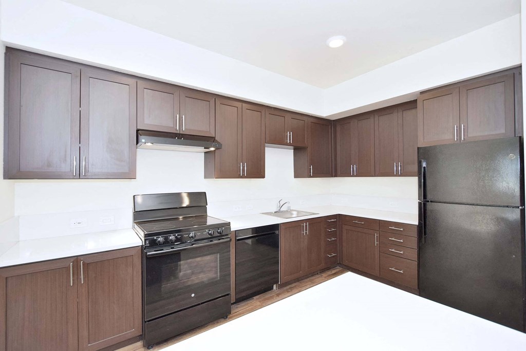 a kitchen with black appliances and wooden cabinets