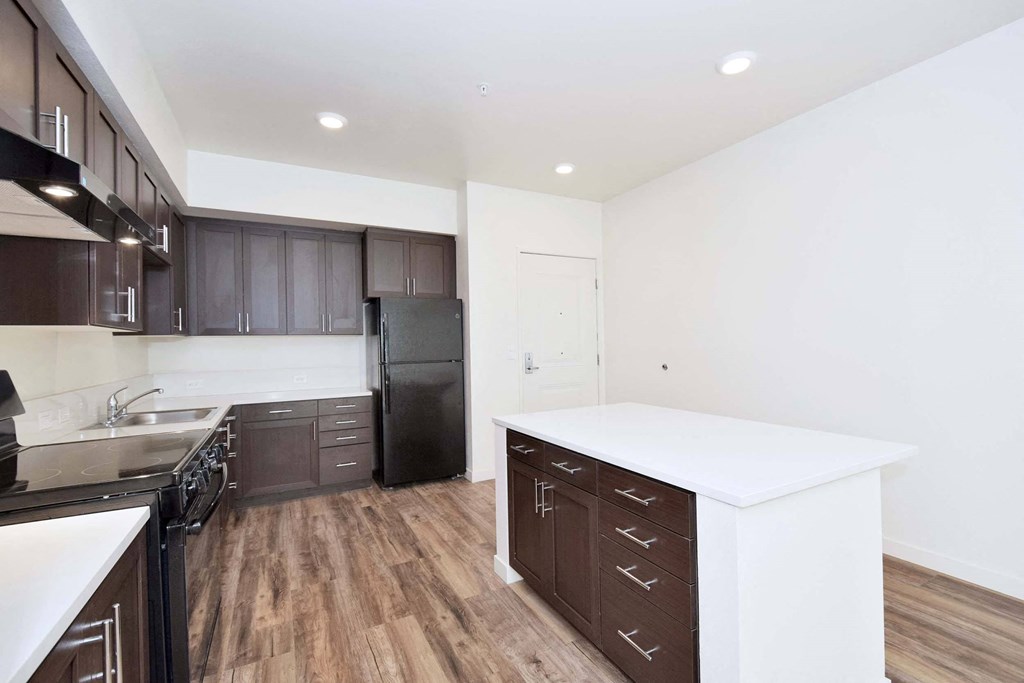 a kitchen with a white counter top and black appliances