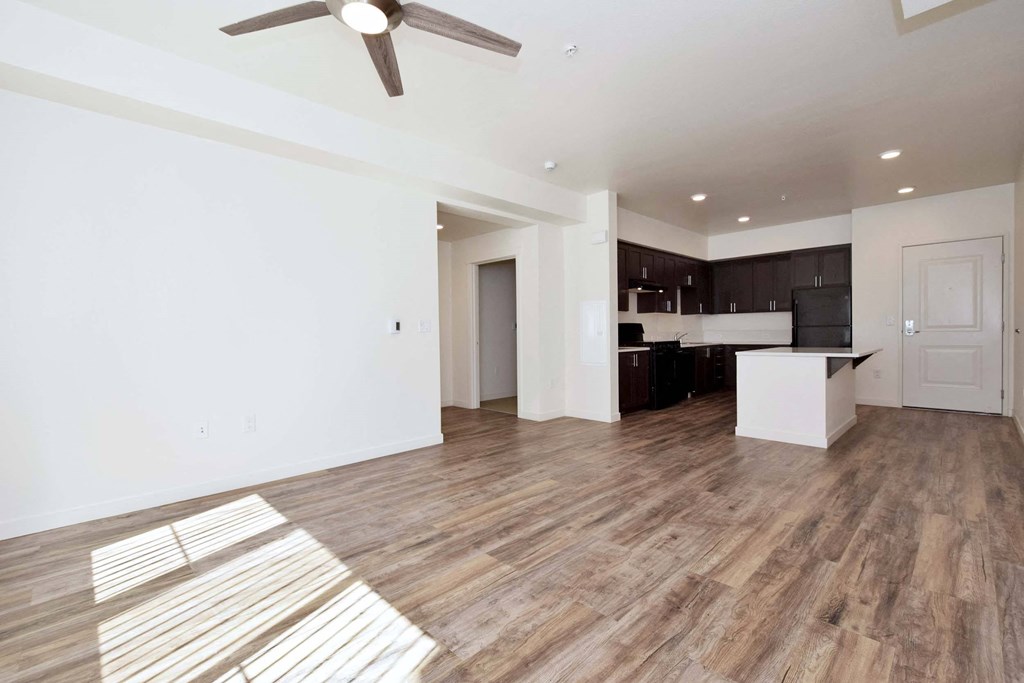 an open living room and kitchen with a ceiling fan