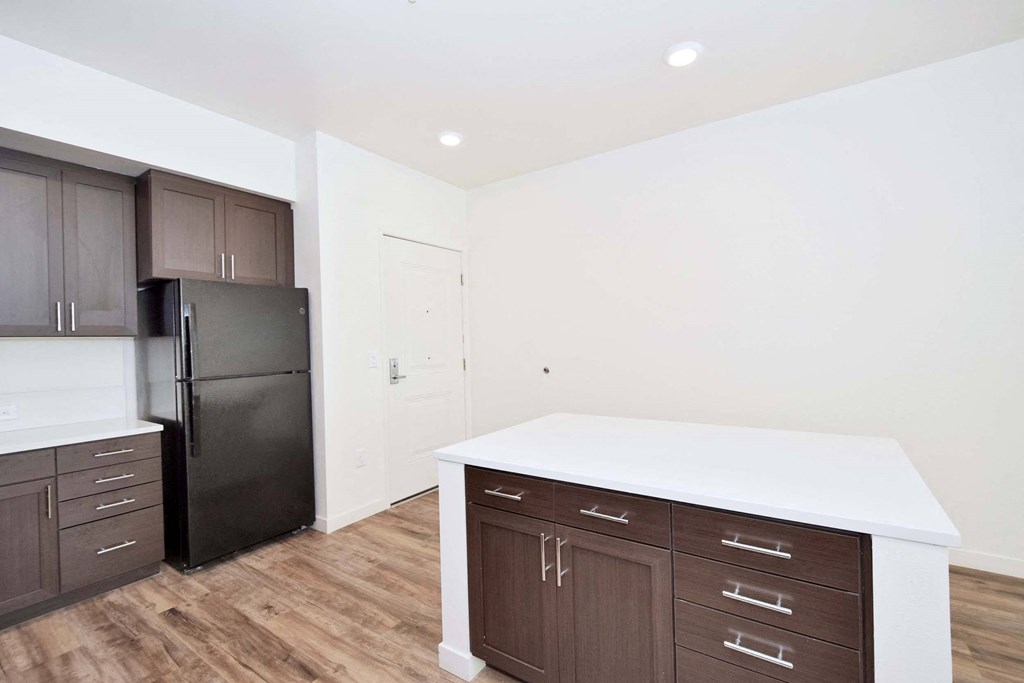 a kitchen with a white counter top and black refrigerator