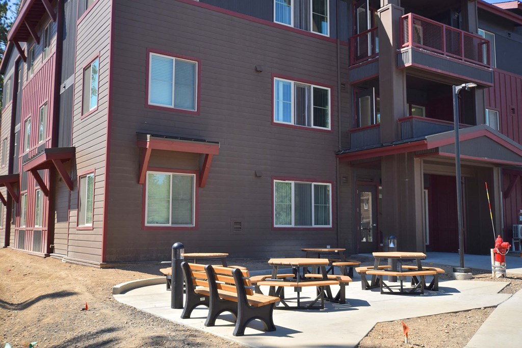 a group of tables and benches outside of a building