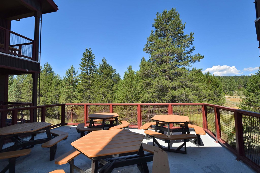 the deck of the cabin with picnic tables