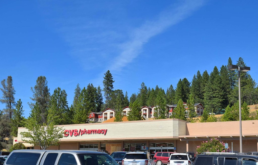 a pharmacy with cars parked in front of it