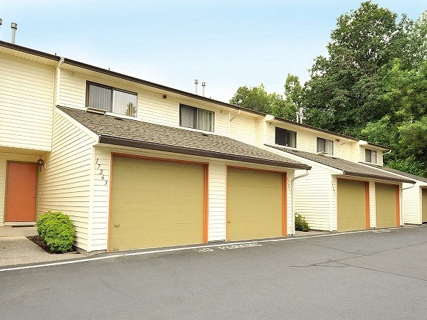 a row of yellow buildings with yellow garage doors