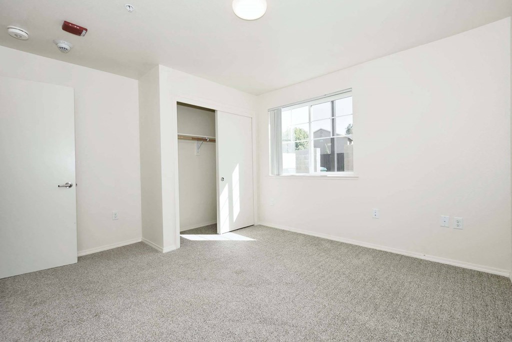 a bedroom with white walls and carpet