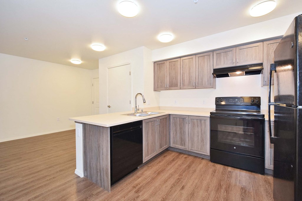 a kitchen with wooden cabinets and a black stove top oven