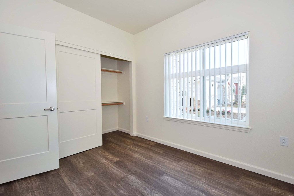 a bedroom with a large window and a closet