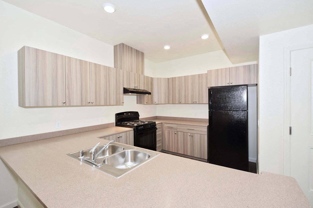 a kitchen with a sink and a black refrigerator
