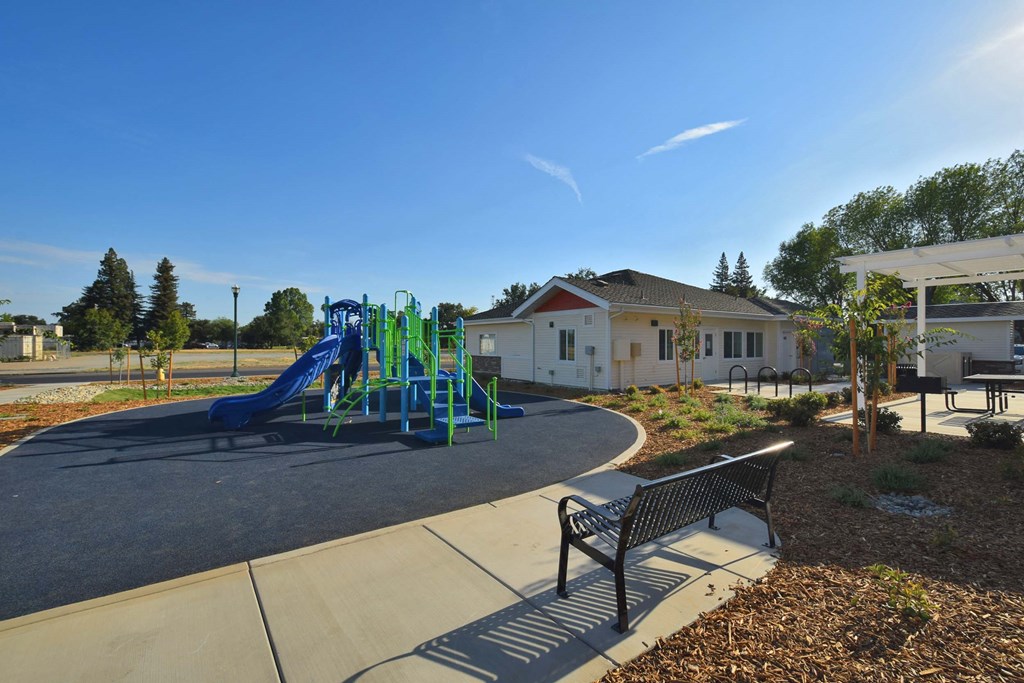 our playground is in front of our clubhouse and has a park bench