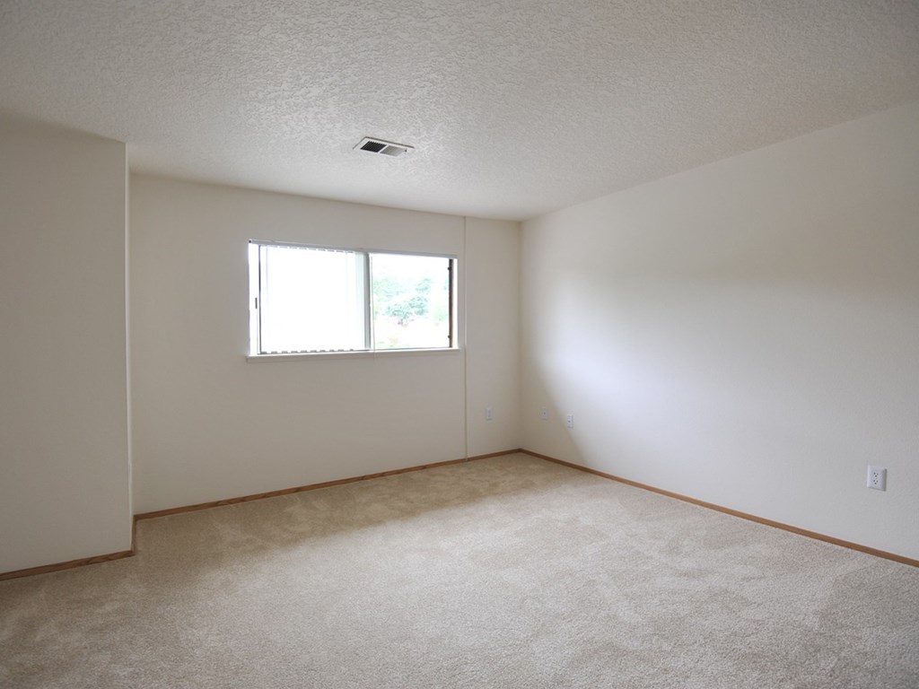 the living room of an empty house with a window