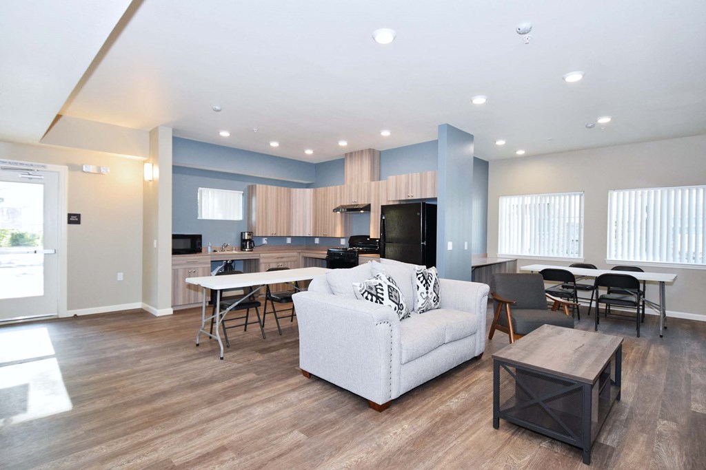 a living room and kitchen with a couch and a table