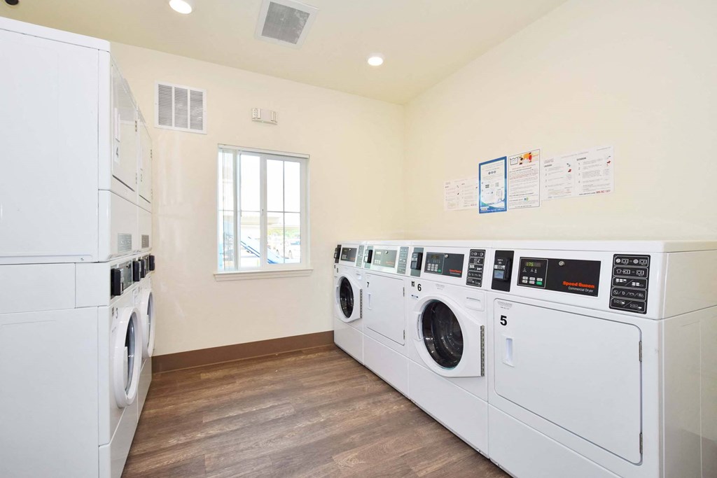 a laundry room with washes and dryers and a window