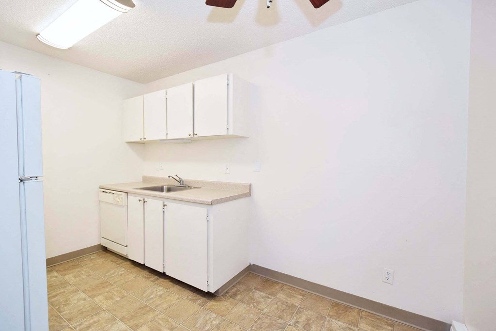 a kitchen with white cabinets and a sink and a refrigerator