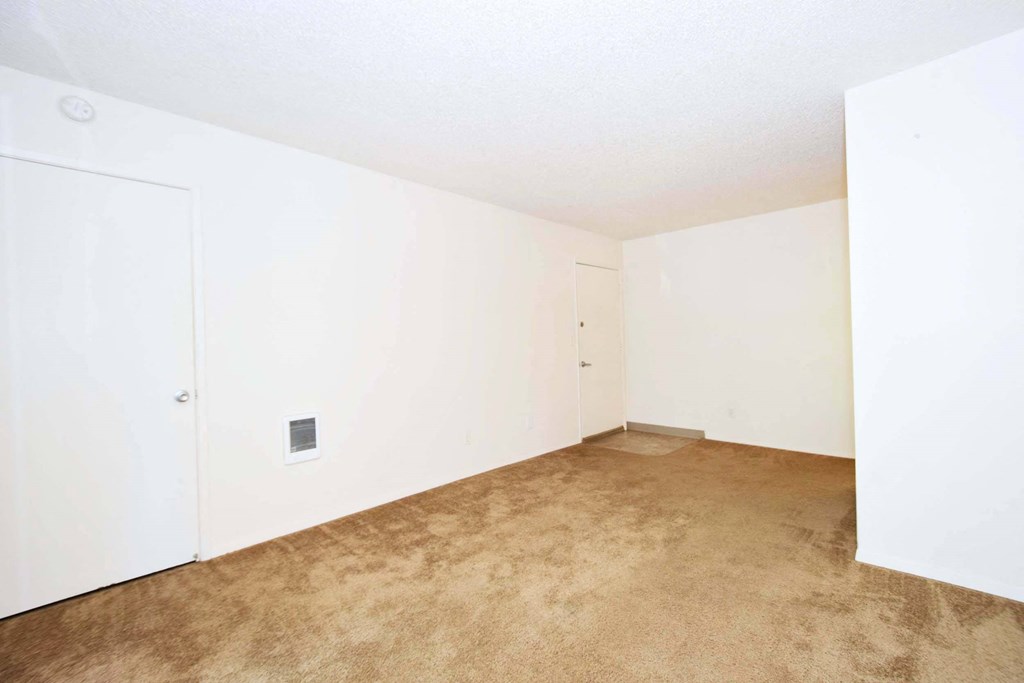 an empty room with carpet and white walls