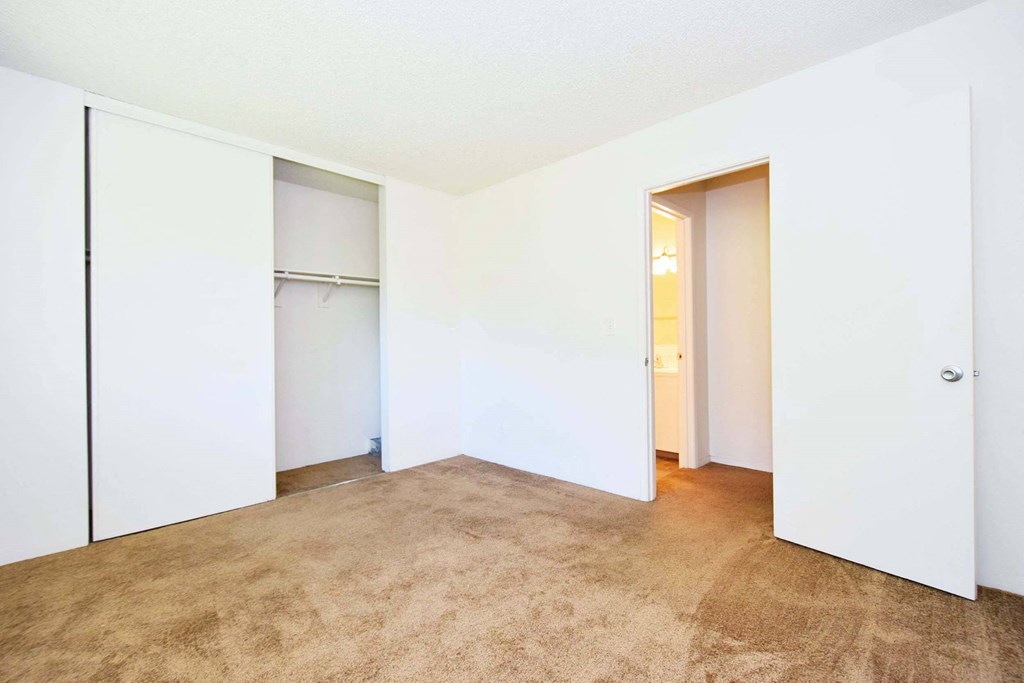 an empty room with white walls and a closet