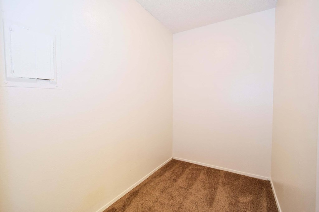 a room with a carpeted floor and a white wall