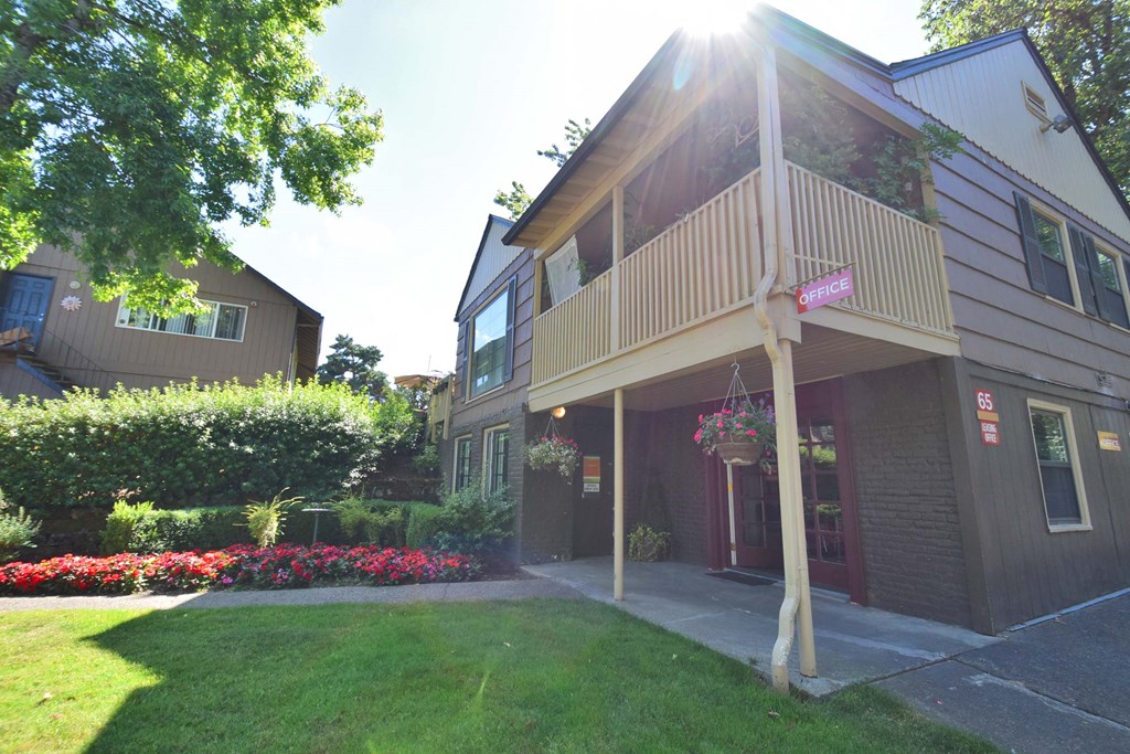 the front of a building with a porch and a lawn