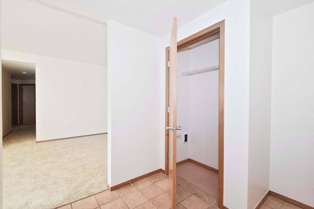 an empty room with a door to a closet