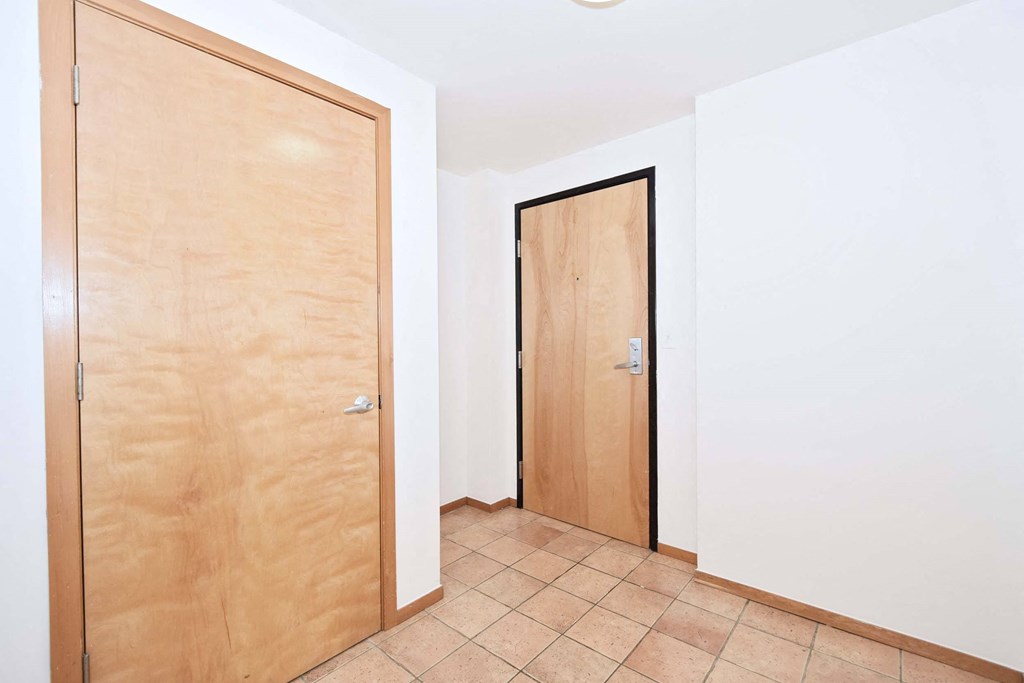 an empty room with two doors and a tiled floor