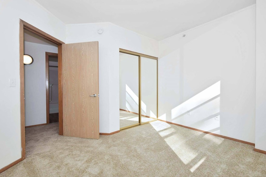 a living room with a door and a carpeted floor