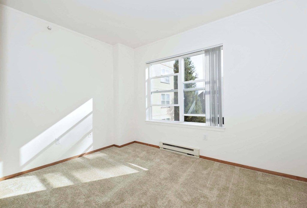 a living room with a large window and carpet