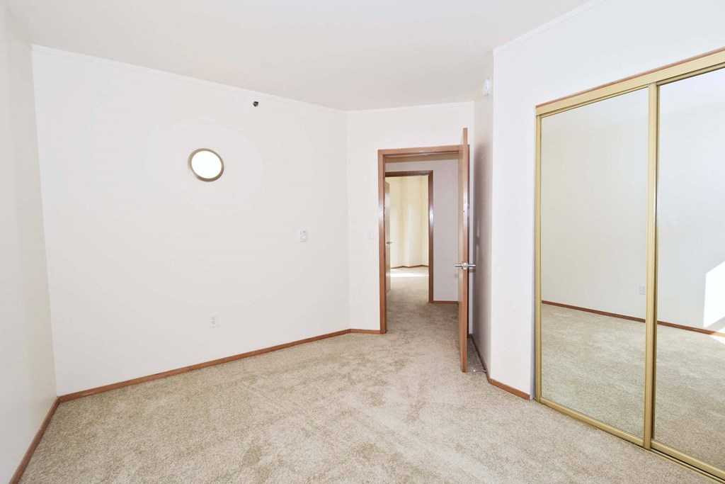 a empty room with a mirror and carpet