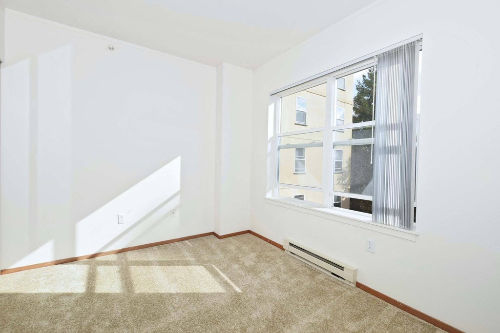 a living room with a large window and carpet