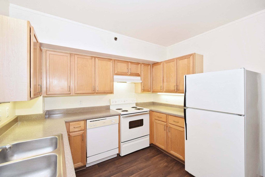 a kitchen with white appliances and wooden cabinets