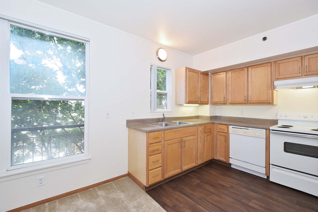 a kitchen with wooden cabinets and a large window