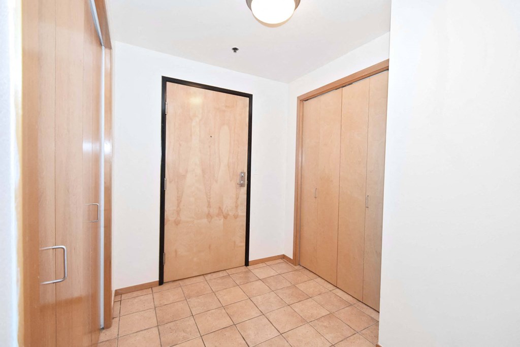 a room with two wooden doors and a tiled floor