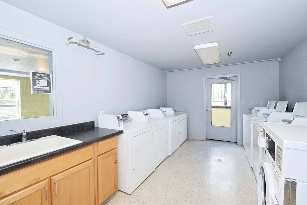 a laundry room with white washes and dryers in it