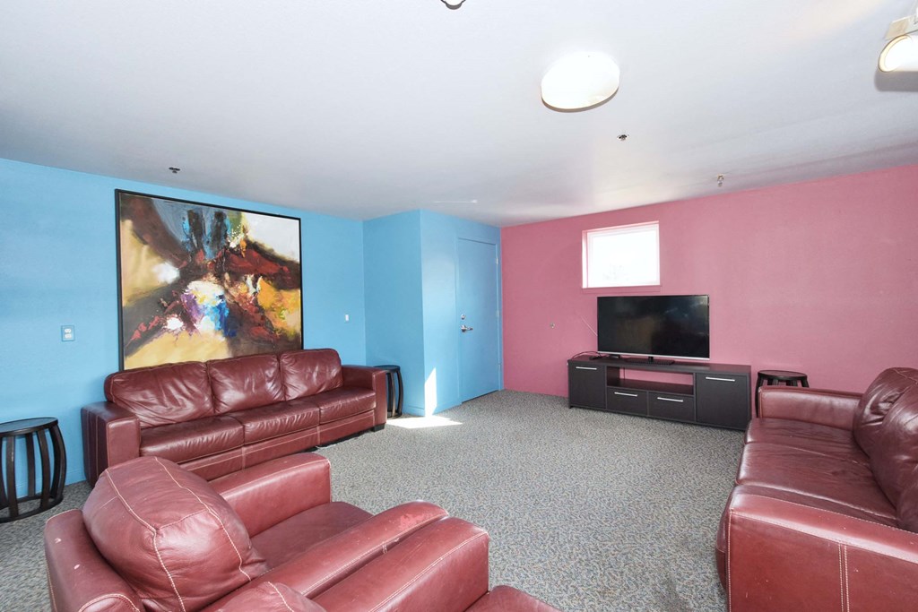 a living room with red leather couches and a tv