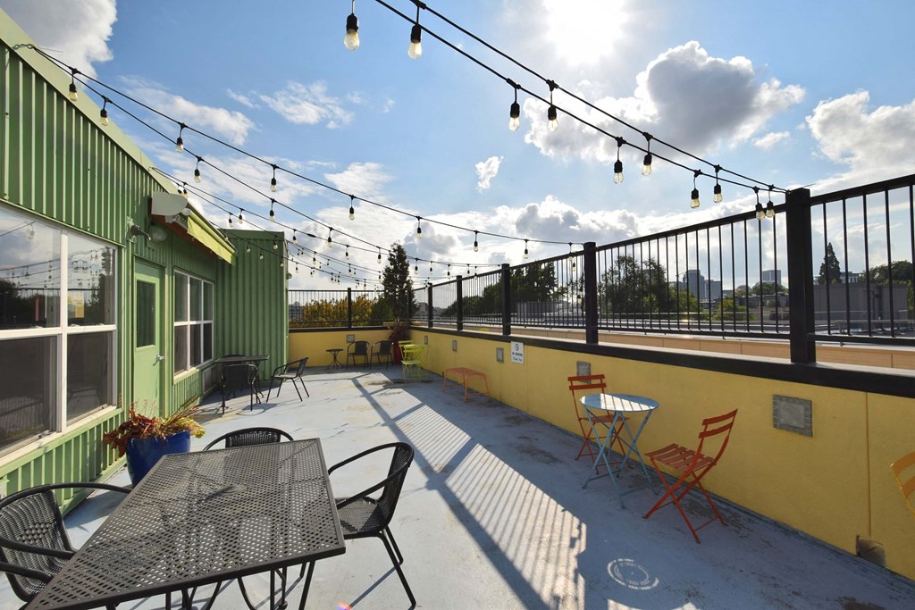 the patio on the roof of the building has tables and chairs
