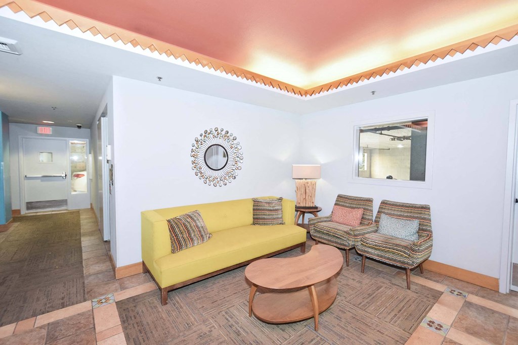 a living room with a yellow couch and two chairs