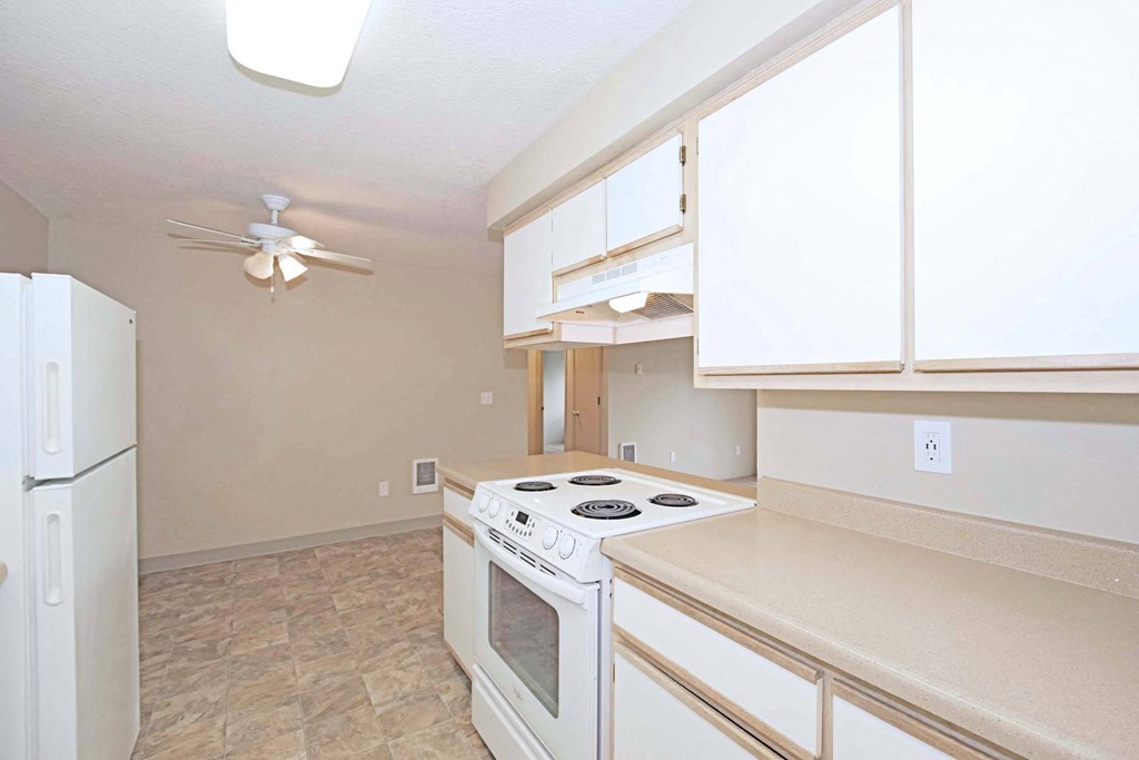 a kitchen with a white stove and a refrigerator