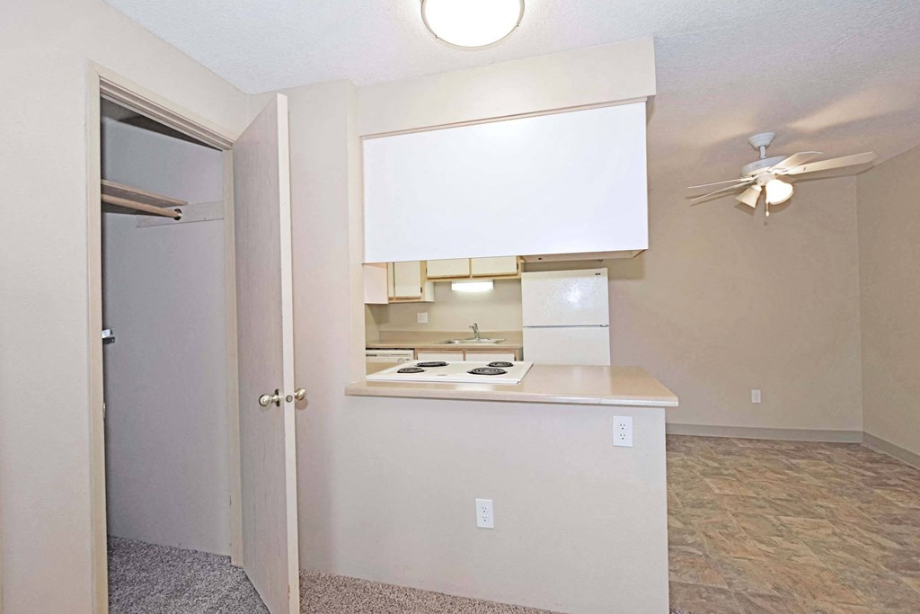an empty kitchen with a ceiling fan and a sink
