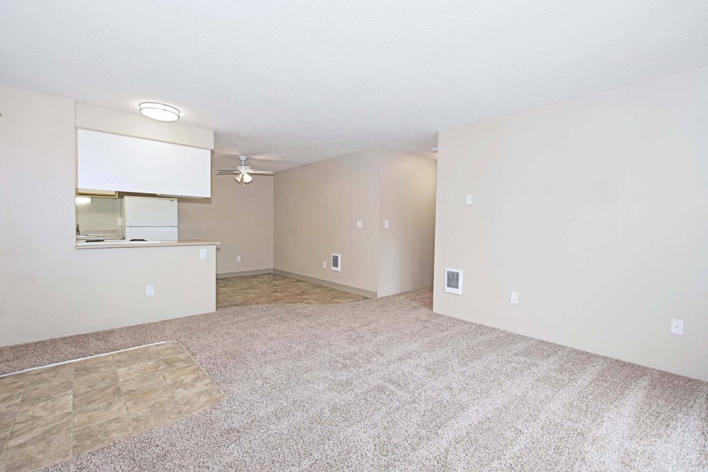 the living room and kitchen of an empty apartment