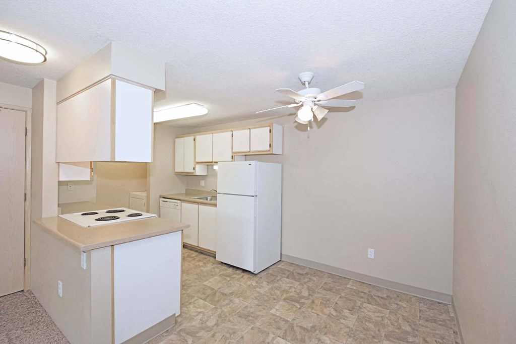 a kitchen with white cabinets and a white refrigerator