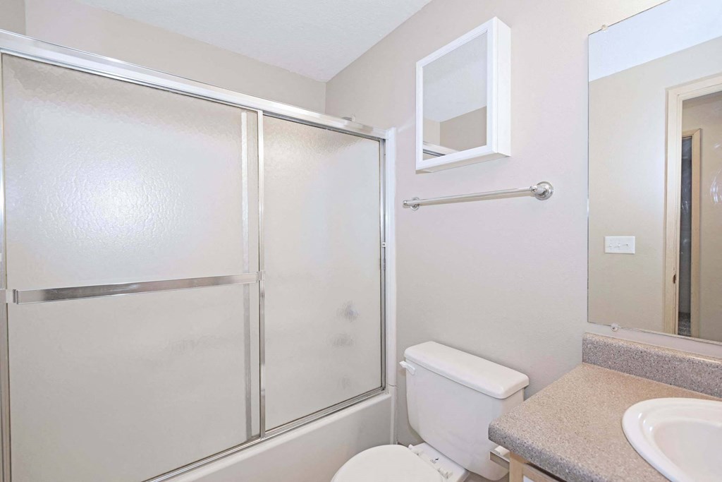 a bathroom with a shower and a sink and a toilet