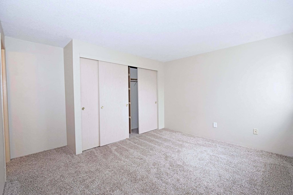 an empty room with white walls and carpet