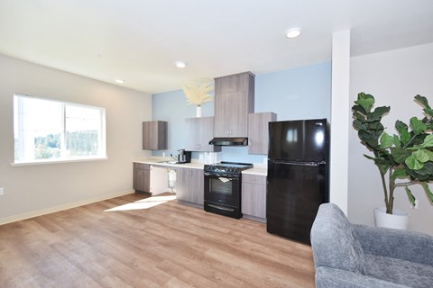 a kitchen and living room with a refrigerator and a sink