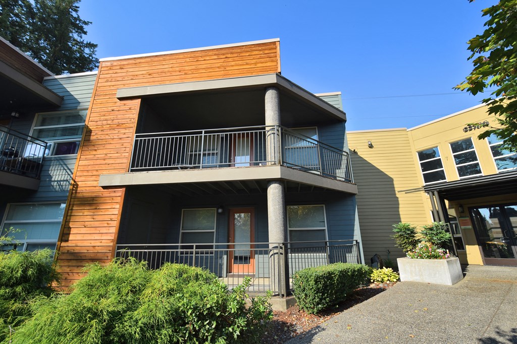 the exterior of a building with a balcony and a sidewalk