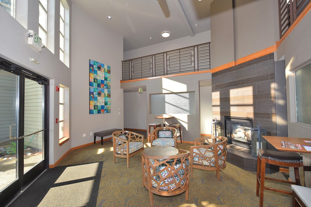 a living room with tables and chairs and a fireplace